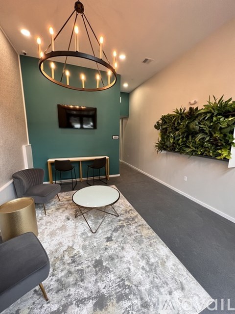A living room with a grey carpet and a green wall.
