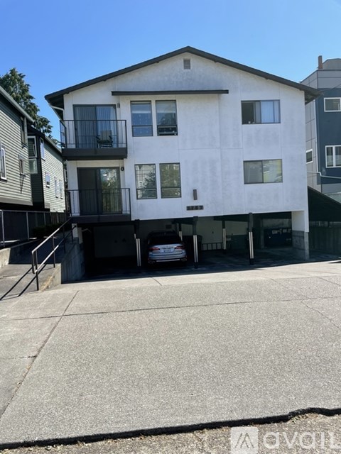 A two-story white house with a balcony on the second floor.