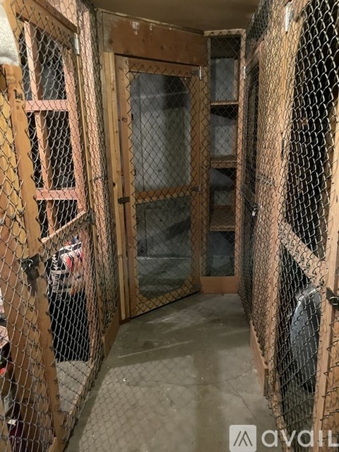 A room with a chain link fence and a wooden door.