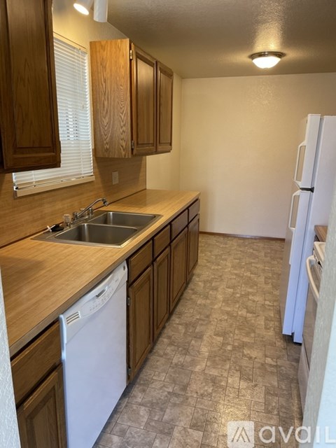 A kitchen with wooden cabinets and a white refrigerator.