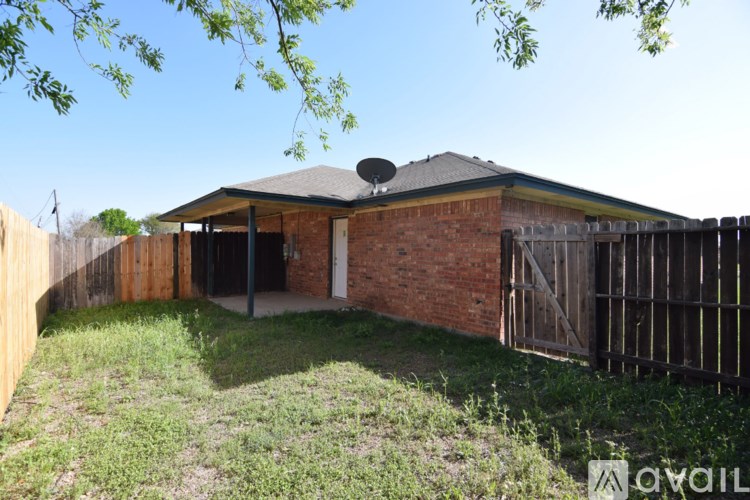 A house with a fence and a satellite dish on the roof.