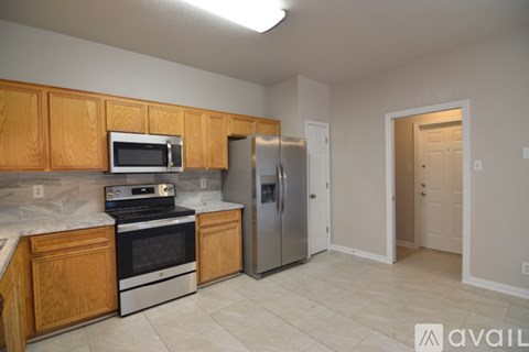 A kitchen with wooden cabinets and a stainless steel refrigerator.
