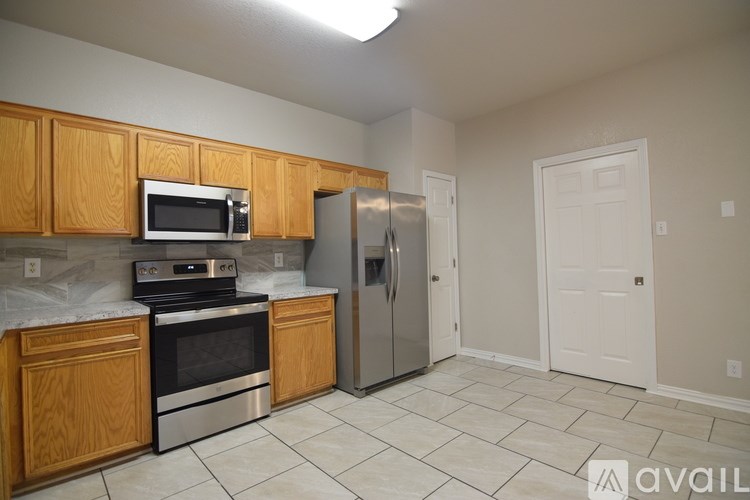 A kitchen with wooden cabinets and stainless steel appliances.