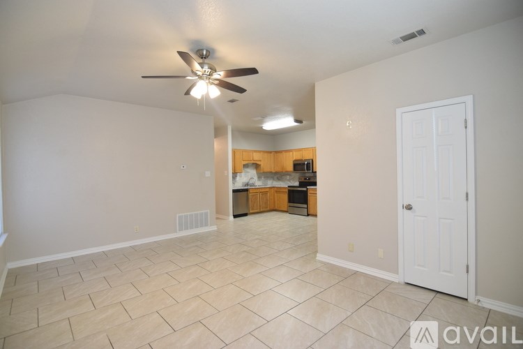 A room with a ceiling fan and a window with blinds.