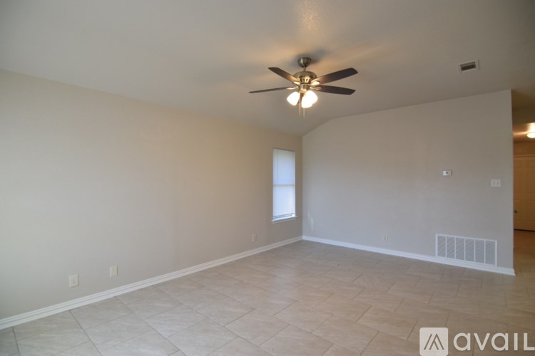 A room with a ceiling fan and a window.