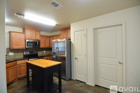 A kitchen with wooden cabinets and a black countertop.