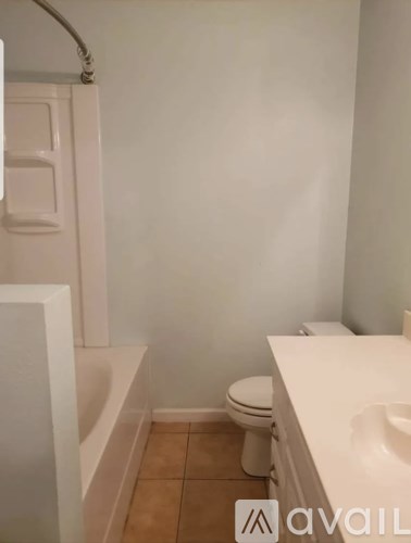 A bathroom with a toilet, sink and bathtub.