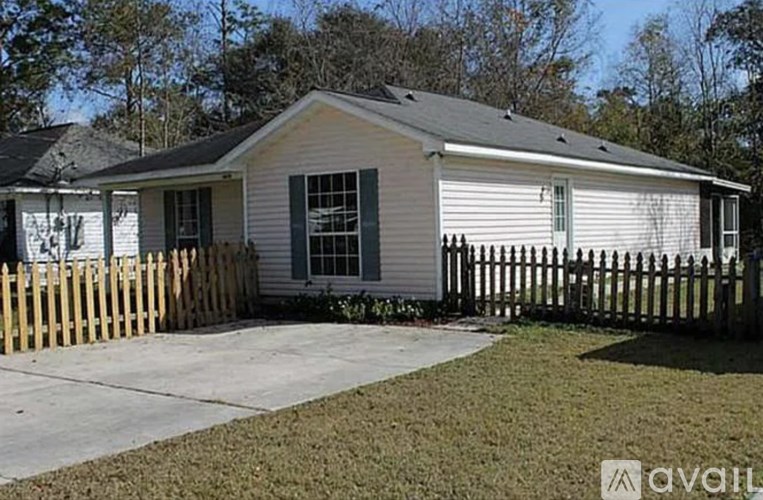 A small house with a wooden fence in front.