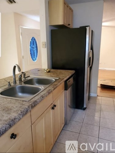 A kitchen with a sink and a refrigerator.