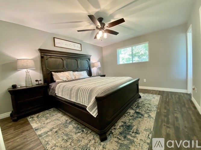 A bedroom with a large bed and a ceiling fan.