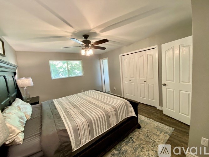 A bedroom with a bed, a ceiling fan, and a rug.