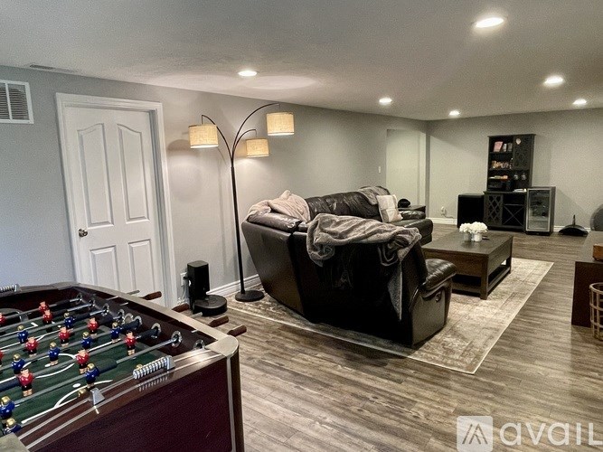 A living room with a foosball table and a couch.
