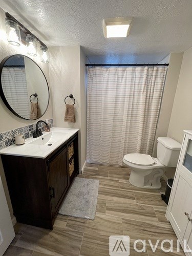 A bathroom with a toilet, sink, and shower.