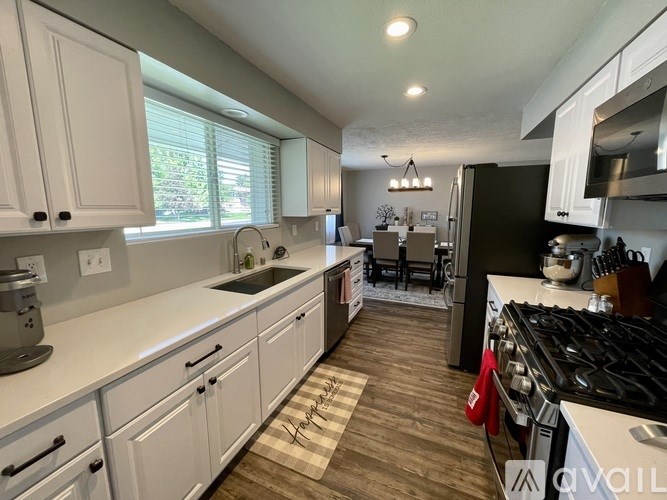 A kitchen with white cabinets and a black refrigerator.