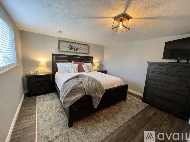 A bedroom with a bed, nightstands, and a ceiling light.