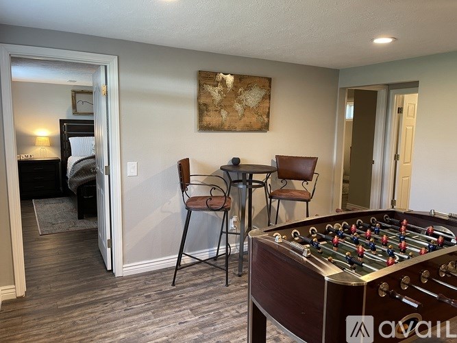 A foosball table is in the middle of a room with a chair and a table.