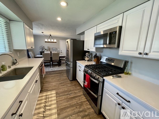 A kitchen with white cabinets and a black stove top oven.
