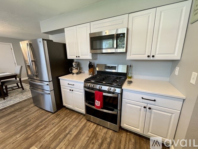 A kitchen with white cabinets and a black stove top oven.