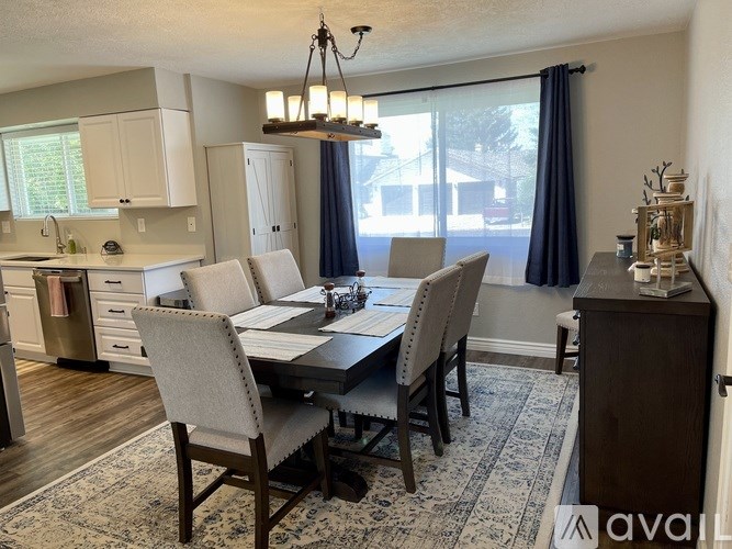 A dining room with a table and chairs.
