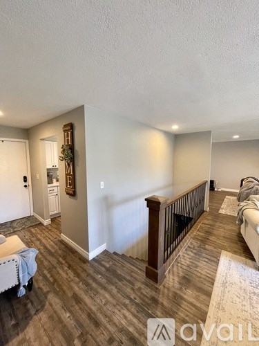 A living room with a white couch and a wooden floor.