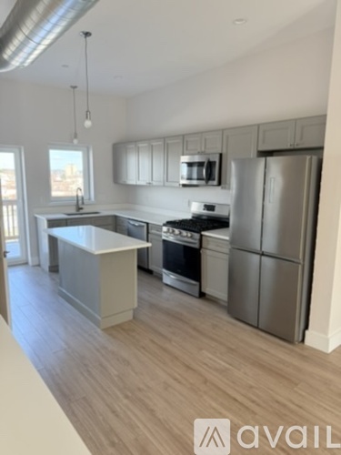 A kitchen with a white countertop and stainless steel appliances.