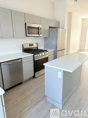 A kitchen with a white fridge, microwave, and oven.