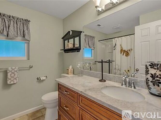 A bathroom with a white toilet, a sink, and a mirror.
