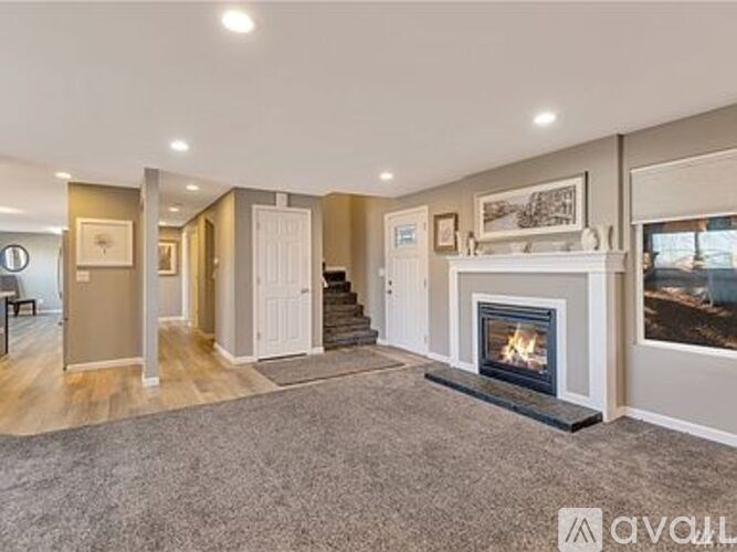 A living room with a fireplace and a painting on the wall.
