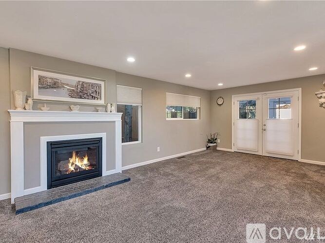 A living room with a fireplace and a painting on the wall.