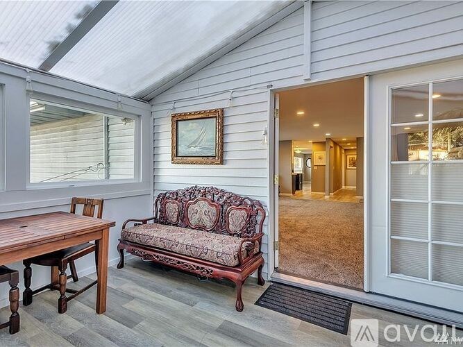 A living room with a couch, table, and a painting on the wall.