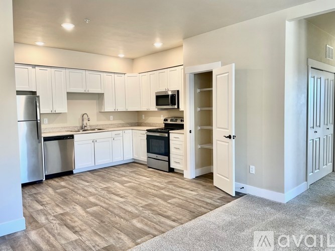 A kitchen with white cabinets and a refrigerator.