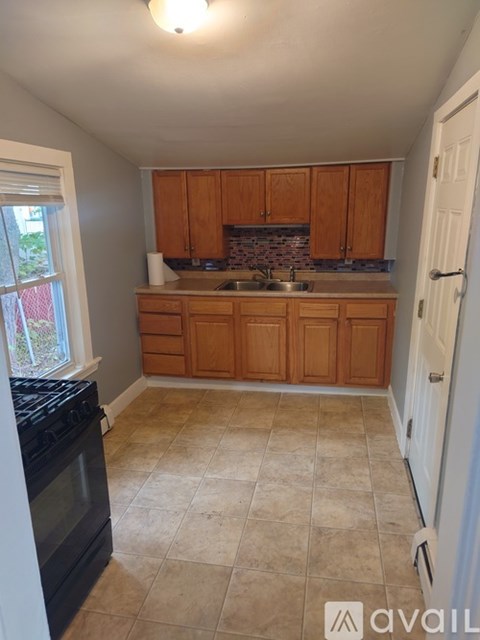 A kitchen with wooden cabinets and a black oven.