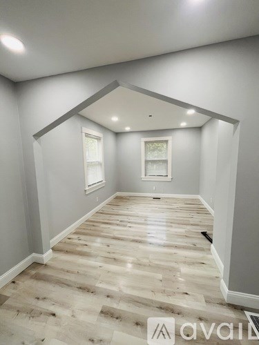 A room with wooden flooring and white walls.