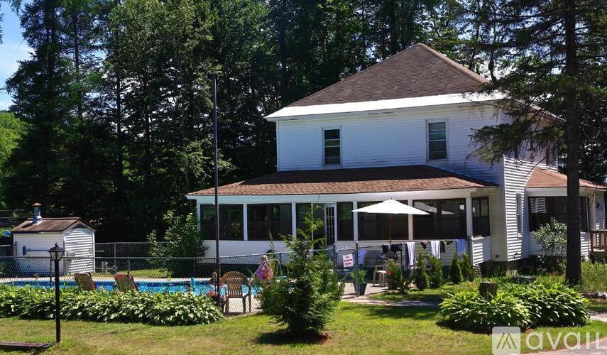 A white house with a pool in the backyard.