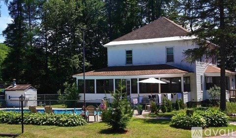 A white house with a pool in the backyard.