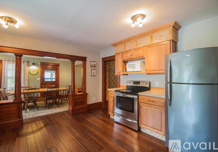 A kitchen with wooden cabinets and a stainless steel refrigerator.