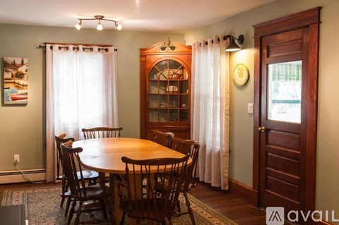 A dining room with a wooden table and chairs.