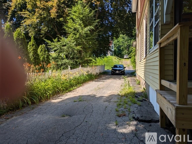 A car is parked on a driveway next to a house.