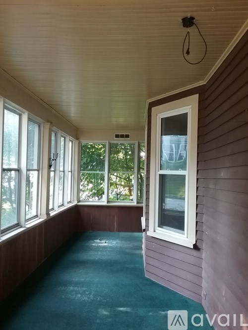 A room with a window and a hanging light fixture.