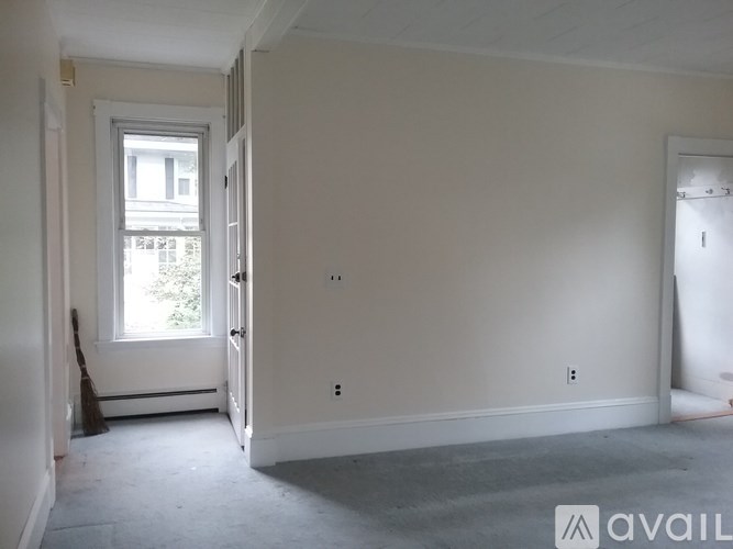 A room with a window and a door is available for rent.