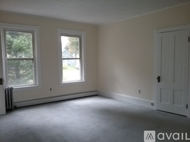 A room with a white door and two windows.