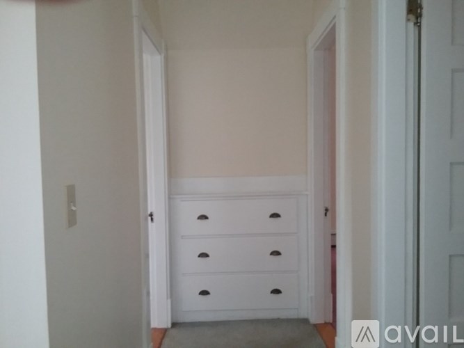 A white drawer unit in a room with white walls.