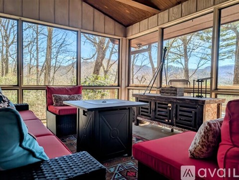 A living room with a red couch and a black fireplace.