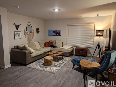 A living room with a grey sofa, a wooden coffee table, and a blue chair.
