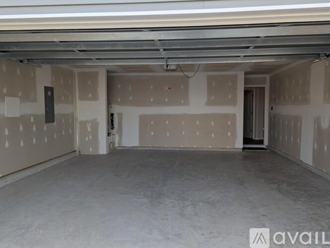 A spacious empty room with drywall installation in progress.