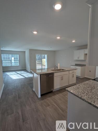 A kitchen with a granite countertop and wooden flooring.