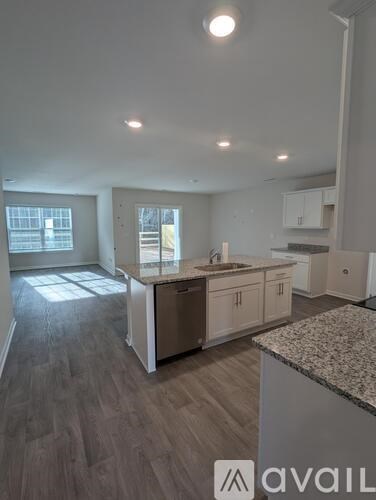 A kitchen with a granite countertop and wooden flooring.