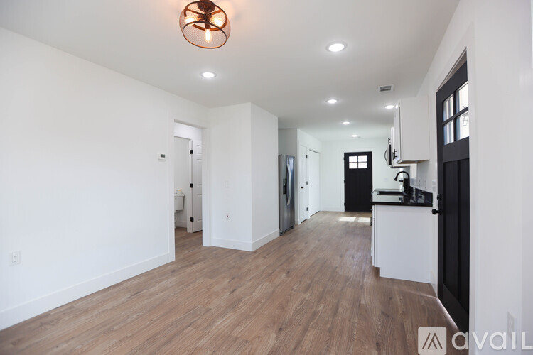 A large empty room with wooden floors and a ceiling light.