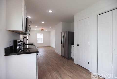 A kitchen with white cabinets and a black countertop.