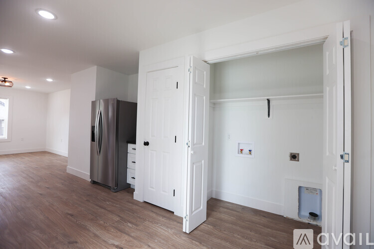 A kitchen with a fridge and a door open to another room.